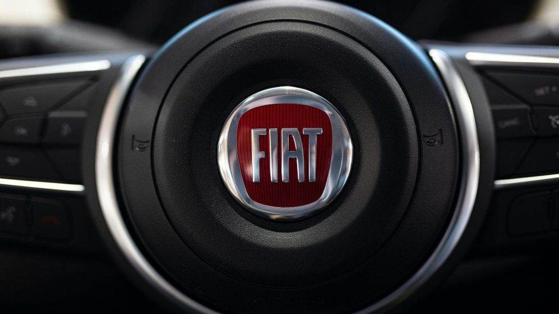 Primo piano di un volante di un'auto Fiat con logo rosso al centro