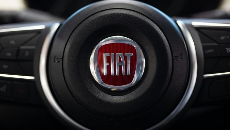Primo piano di un volante di un'auto Fiat con logo rosso al centro
